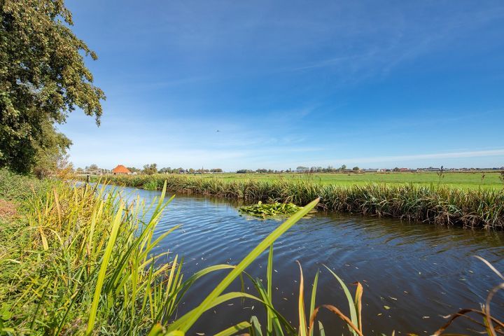 Foto vaart met erachter een weiland gelegen