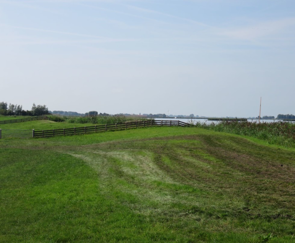 Foto van een lage kade met zicht op de boezem