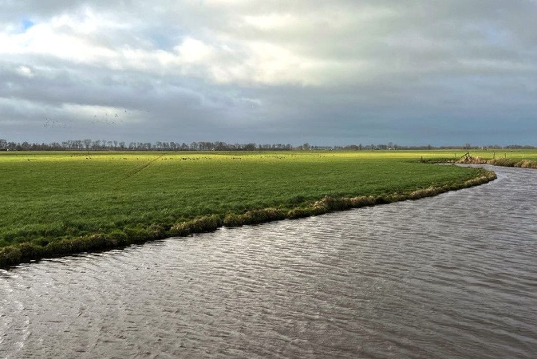 Foto van landschap in ADD met weiland en water