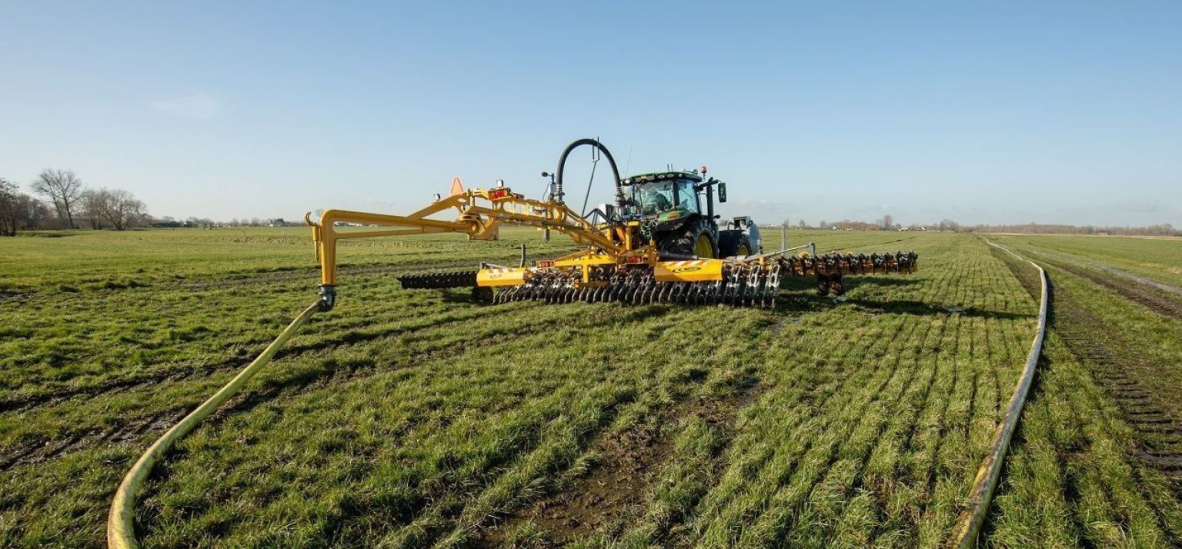 Foto van bemesting door een tractor met een sleepslang