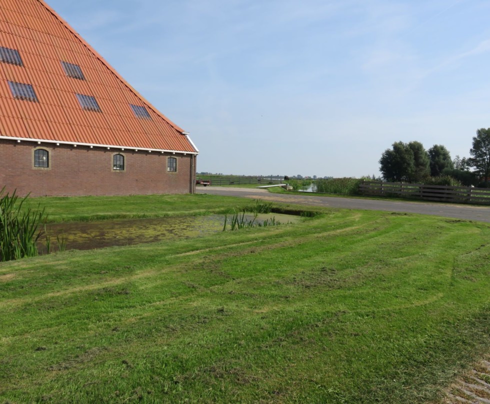 Foto van boerderij met ernaast gelegen een hoogwatercircuit